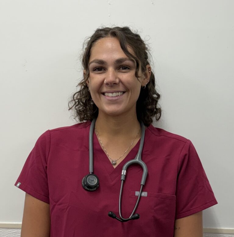 woman in scrubs standing with stethoscope